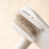 Close-up of the deshedding bristles with loose cat fur